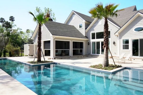 A large pool with palm trees in the backyard.