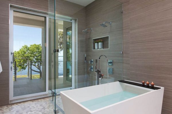 A bathroom with a large tub and glass shower door.
