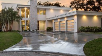 A large white house with three garage doors.