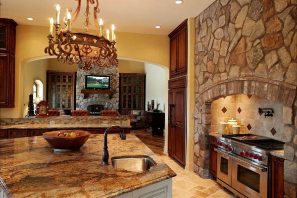 A kitchen with stone walls and a large island.