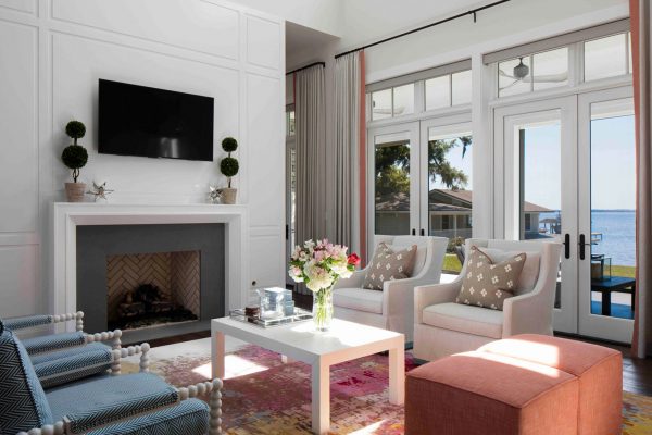 A living room with white furniture and fireplace.