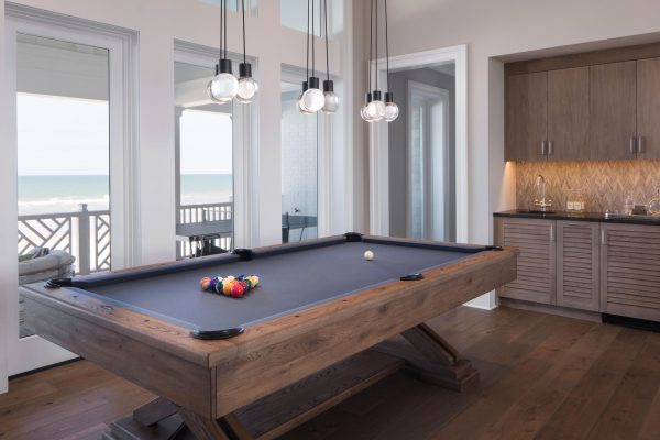 A pool table in the middle of a room with a view.