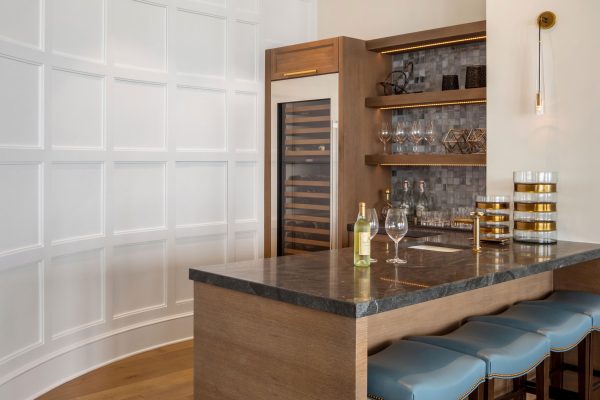 A kitchen with a bar and wine storage.