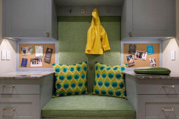 A green and yellow bench with two pillows.
