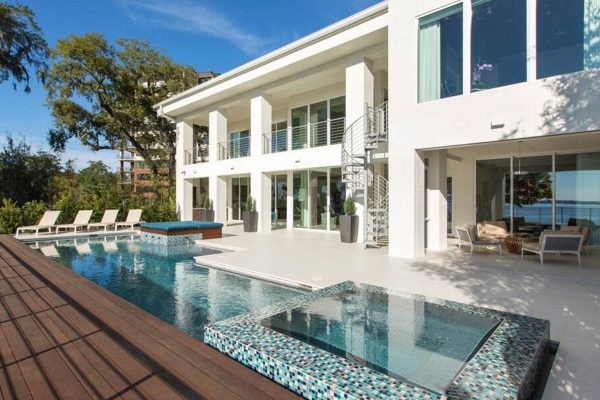 A large pool with a glass bottom and a deck.