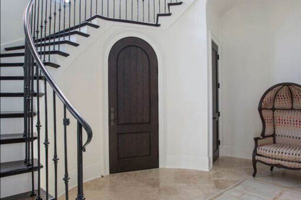 A staircase with wrought iron railing and wood steps.