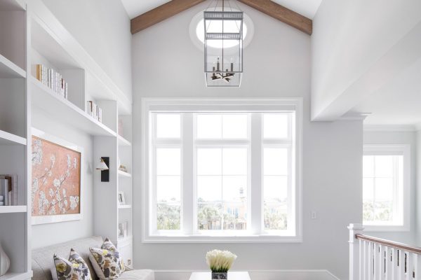 A living room with white walls and wooden ceiling beams.