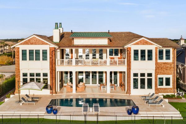 A large brick house with pool and patio furniture.