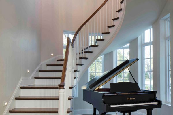 A grand piano is on the stairs in this home.